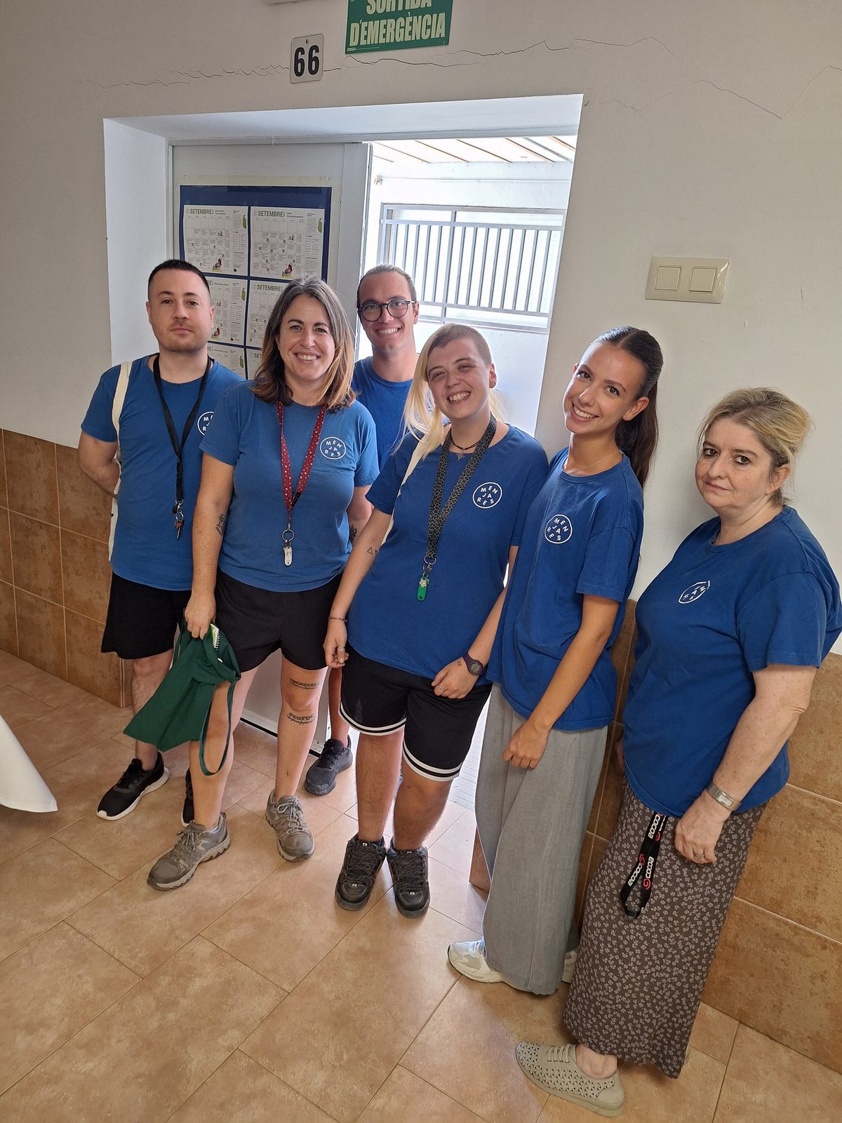 L’equip de l’Espai Migdia del centre, amb samarreta blava, a l’entrada del menjador.